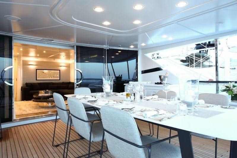a large white table with chairs and a large glass window aboard SUD Yacht for Charter