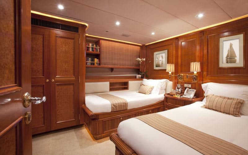 a room with a bed and a bookcase aboard GENEVIEVE Yacht for Charter