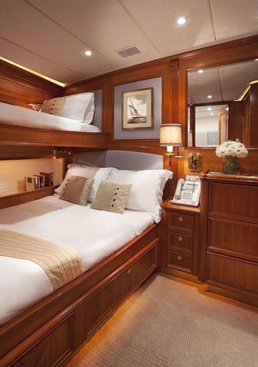 a bedroom with a bed and a mirror aboard GENEVIEVE Yacht for Charter