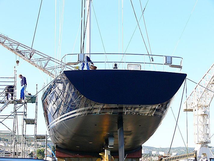 a large boat with a large blue sail aboard THANDEKA Yacht for Charter
