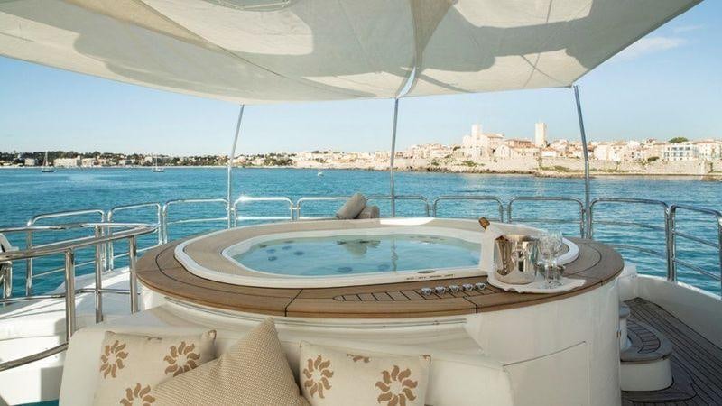 a large white lounge chair on a balcony overlooking a body of water aboard GIORGIA Yacht for Charter