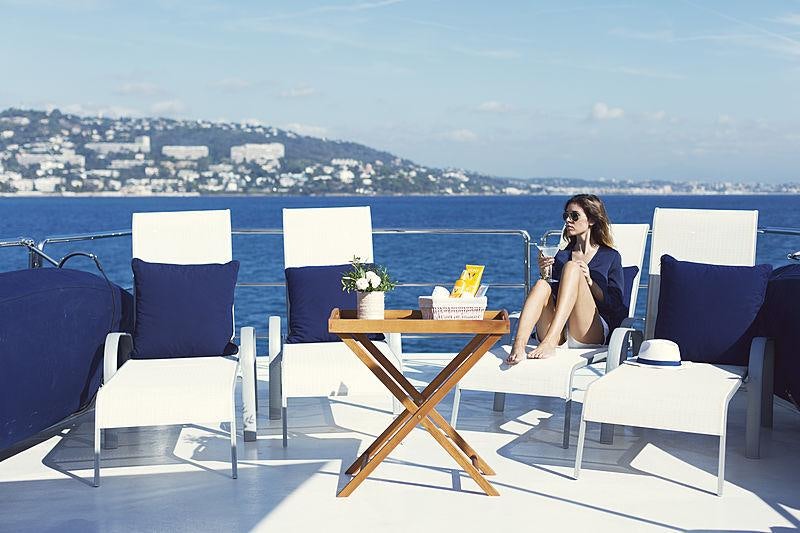 a person sitting at a table on a balcony overlooking a city aboard PRINCESS ILUKA Yacht for Charter