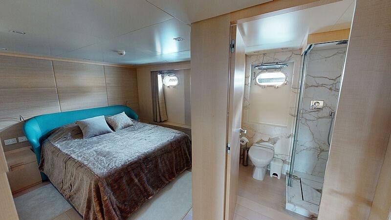 a bedroom with a bed and a shower aboard ATOM Yacht for Charter