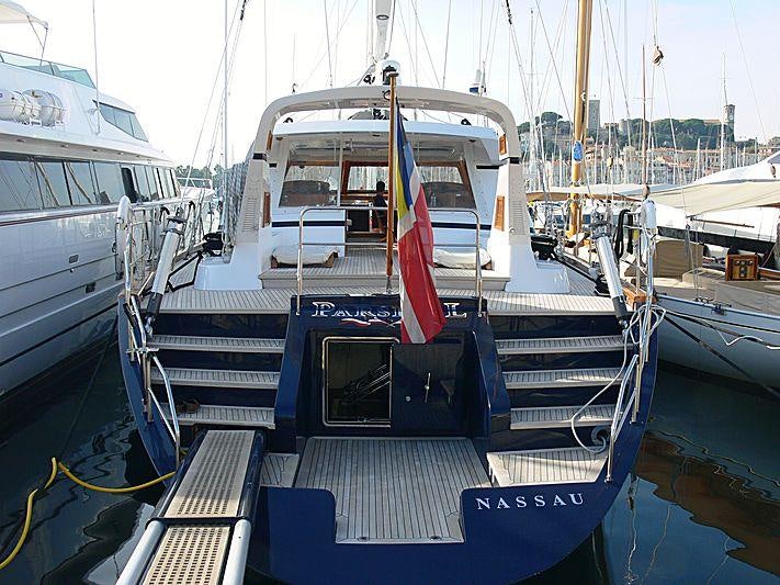 a boat with a flag on it aboard REE Yacht for Charter