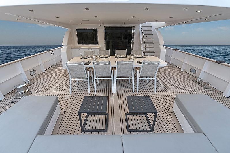 a room with a table chairs and a large pool aboard PROJECT STEEL Yacht for Charter