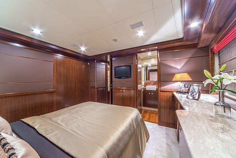 a bedroom with a bed and a table aboard SEVENTH SENSE Yacht for Charter