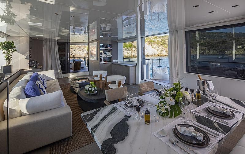 a large room with a table and chairs aboard DINAIA Yacht for Charter