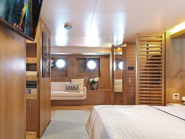 a room with a bed and a chair aboard SOUNION II Yacht for Charter