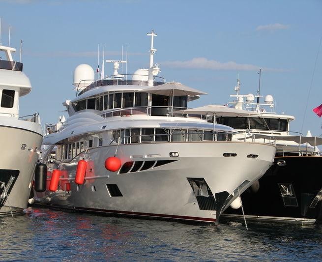 a couple of boats are parked in the water with USS Potomac (AG-25) in the background aboard GATSBY Yacht for Charter
