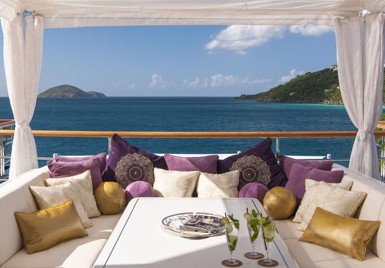 a table with pillows and a view of the ocean aboard SOLANDGE Yacht for Charter