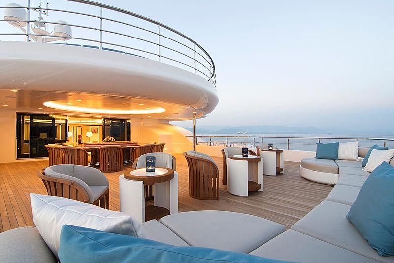 a room with a large bed and a table with chairs aboard O'PTASIA Yacht for Charter