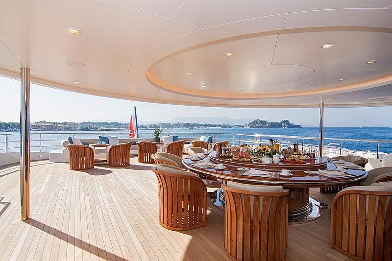 a room with tables and chairs aboard O'PTASIA Yacht for Charter