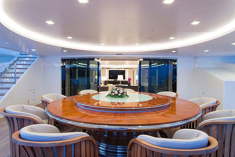 a room with tables and chairs aboard O'PTASIA Yacht for Charter