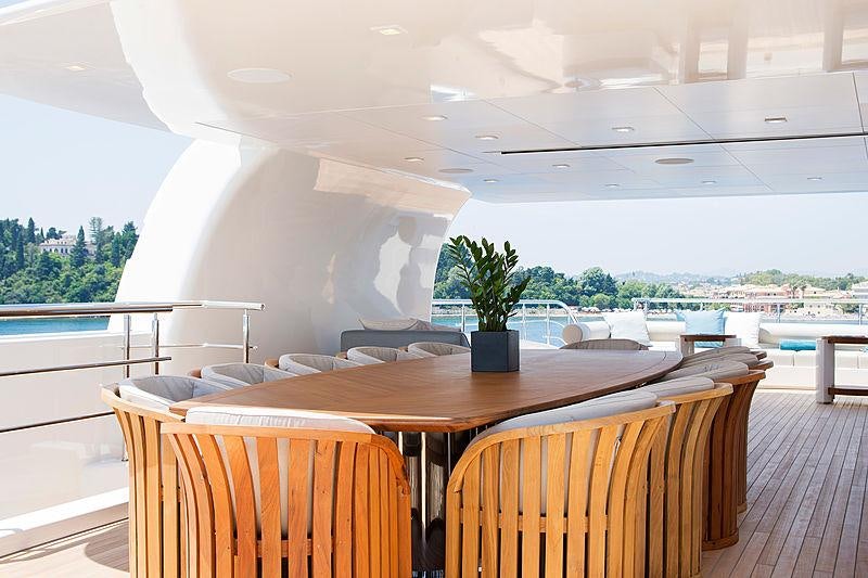 a table with chairs and a plant on it aboard O'PTASIA Yacht for Sale