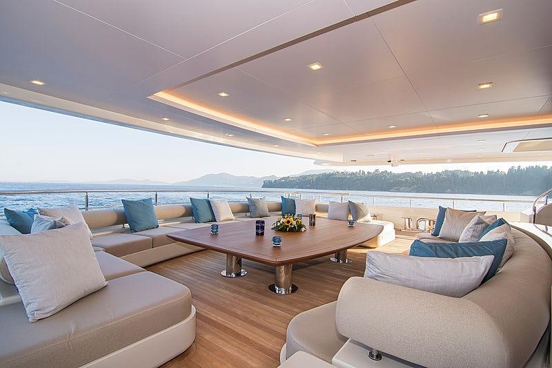 a living room with a large sofa and a large table aboard O'PTASIA Yacht for Charter