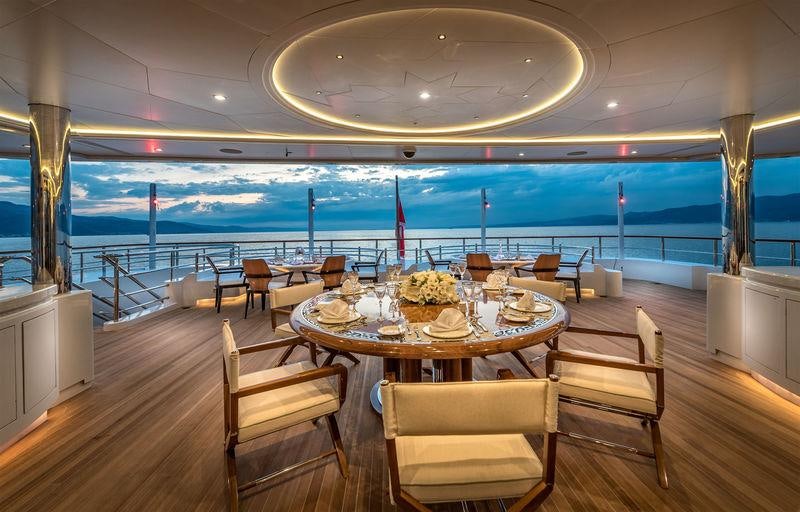 a room with tables and chairs aboard ELEMENTS Yacht for Charter