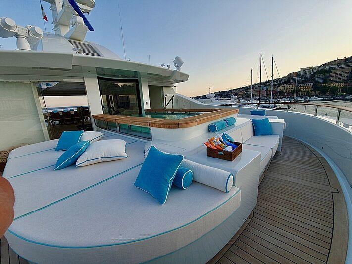 a pool with a deck and lounge chairs on a deck aboard MIMTEE Yacht for Charter