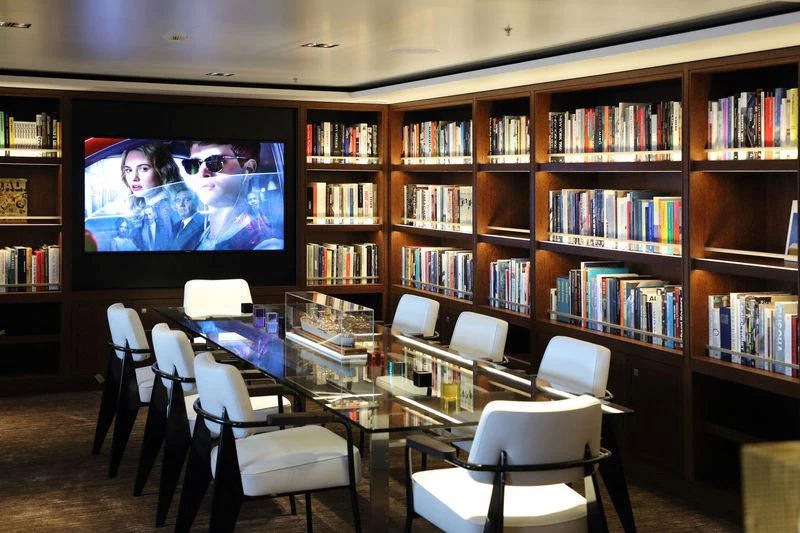 a room with a tv and bookshelves aboard PLANET NINE Yacht for Charter