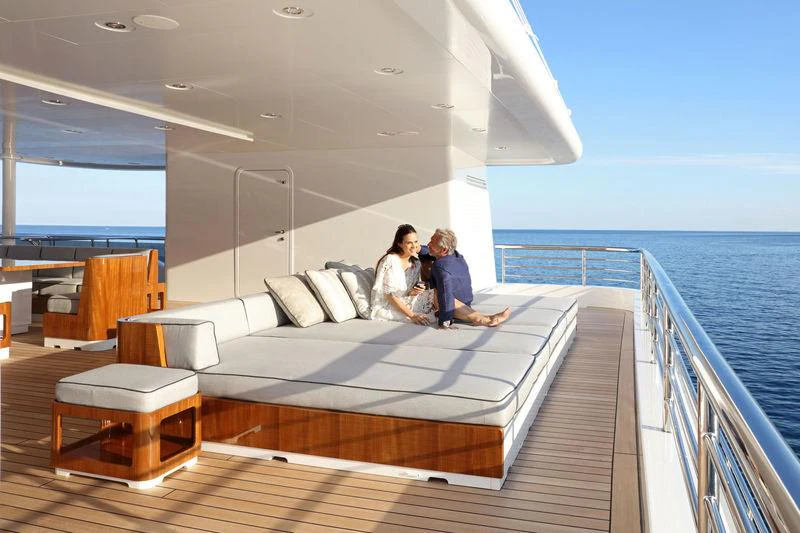 a couple sitting on a couch on a boat aboard PLANET NINE Yacht for Charter