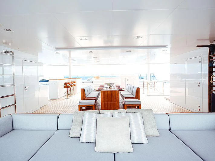 a room with a table chairs and a couch aboard PLANET NINE Yacht for Charter