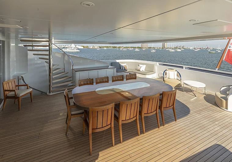 a table and chairs on a deck overlooking a large body of water aboard ILLUSION Yacht for Charter