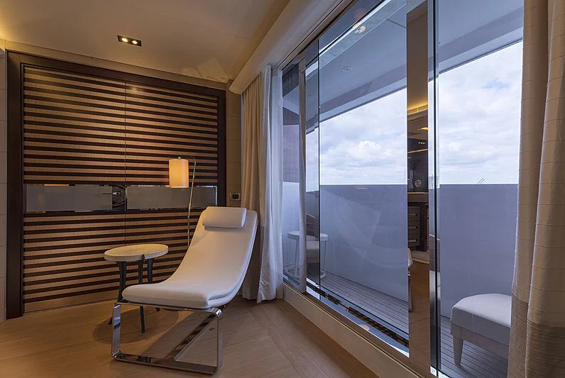a room with a chair and a table and a window aboard ILLUSION Yacht for Charter