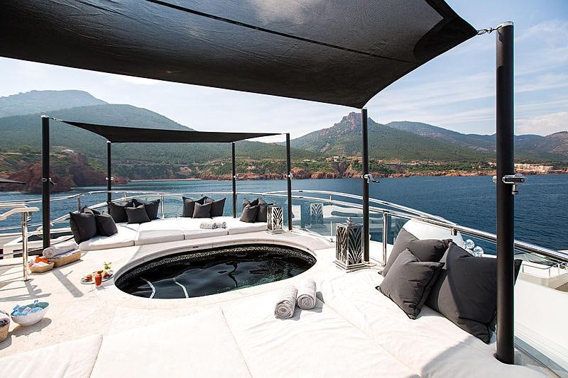 a bed with a white cover and a black and white blanket on it aboard SILVER ANGEL Yacht for Charter