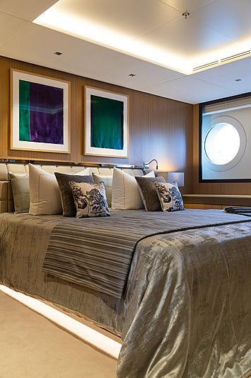 a bed with a large window aboard ARTISAN Yacht for Charter