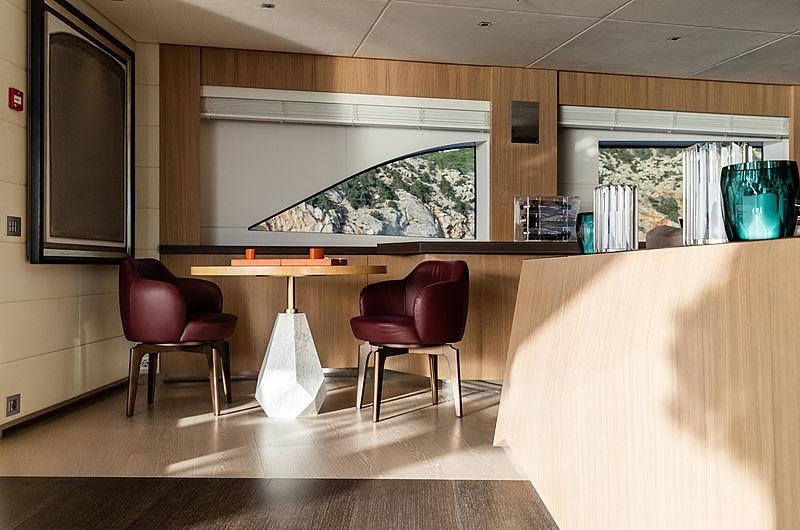 a room with a tv and chairs aboard ARTISAN Yacht for Charter