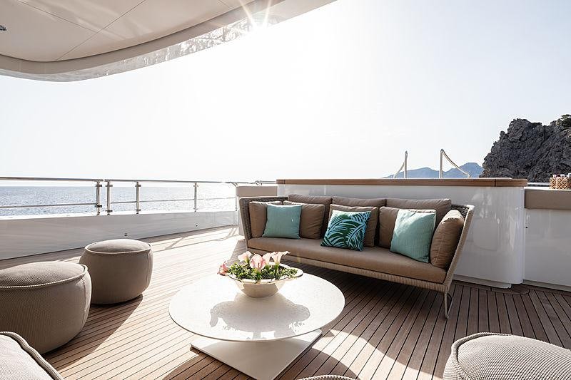 a couch and a table on a balcony aboard ARTISAN Yacht for Charter