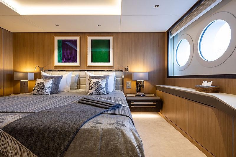 a bedroom with a bed and a mirror aboard ARTISAN Yacht for Charter