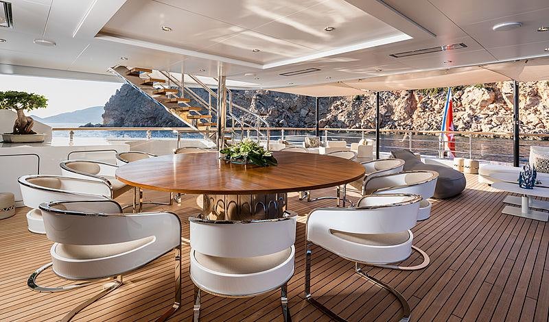 a room with a table chairs and a pool in it aboard ARTISAN Yacht for Charter