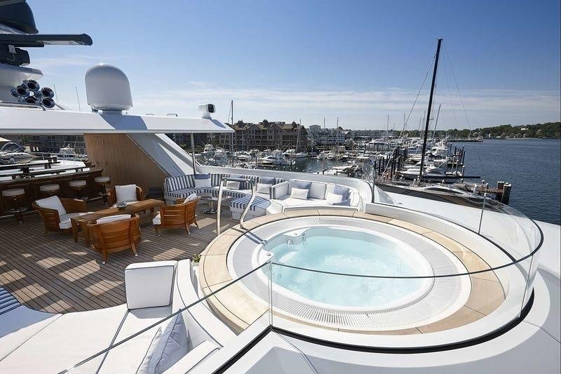 a large swimming pool with a large sailboat in the background aboard ROCK.IT Yacht for Charter
