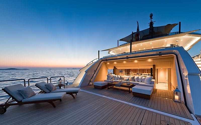 a deck with a large boat on it and a bench on it aboard SAMURAI Yacht for Charter