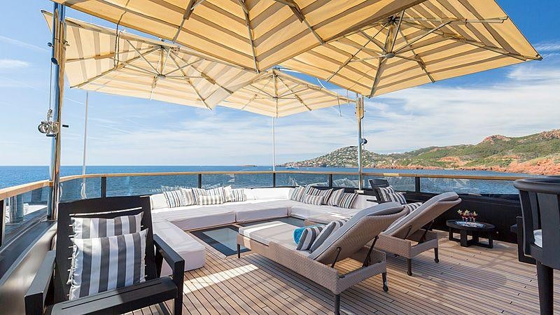 a deck with a view of the ocean and a large beach aboard TAIBA Yacht for Charter