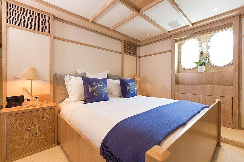 a bed with blue pillows aboard FRIENDSHIP Yacht for Charter