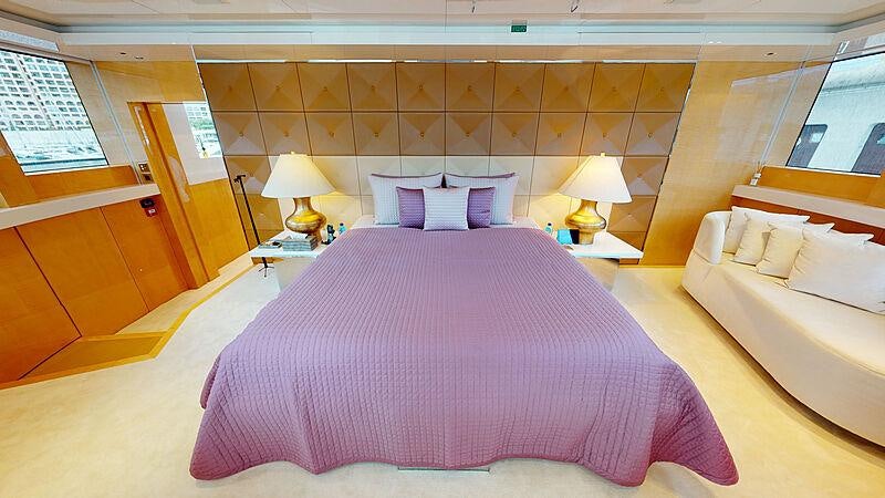 a bed with a purple comforter aboard LA PELLEGRINA 1 Yacht for Charter