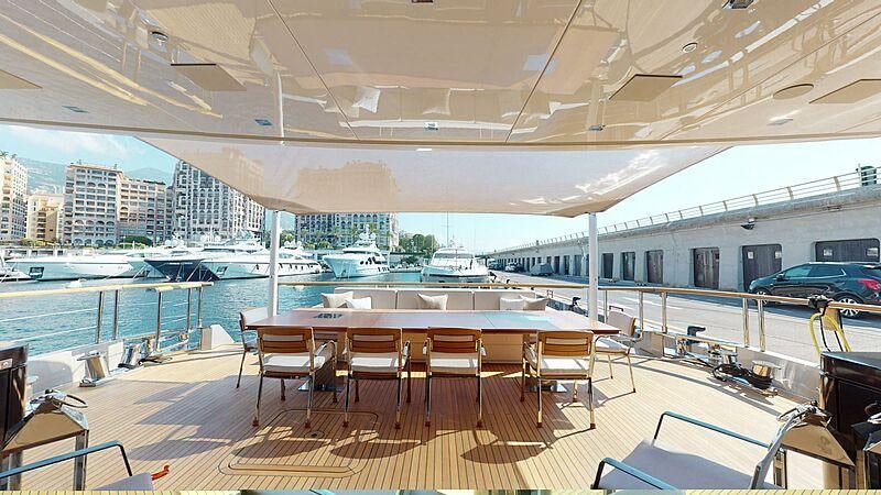 a large room with a table and chairs on a deck aboard LA PELLEGRINA 1 Yacht for Charter