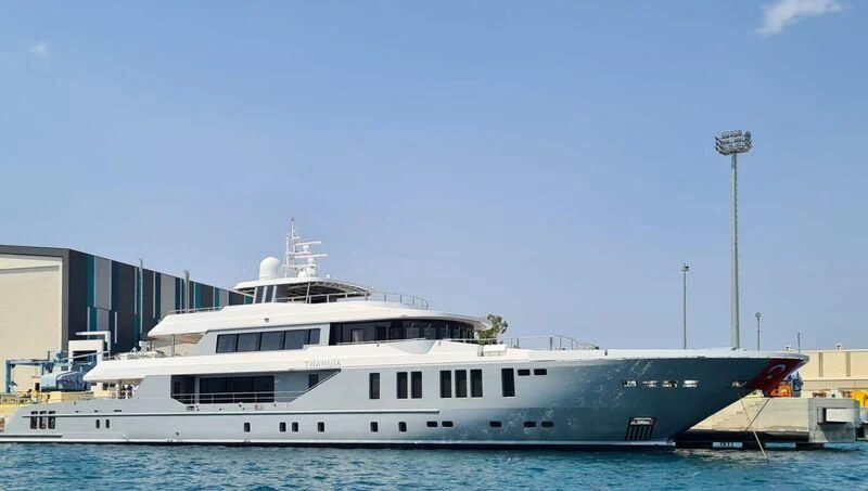 a large white boat in a harbor aboard THANUJA Yacht for Sale