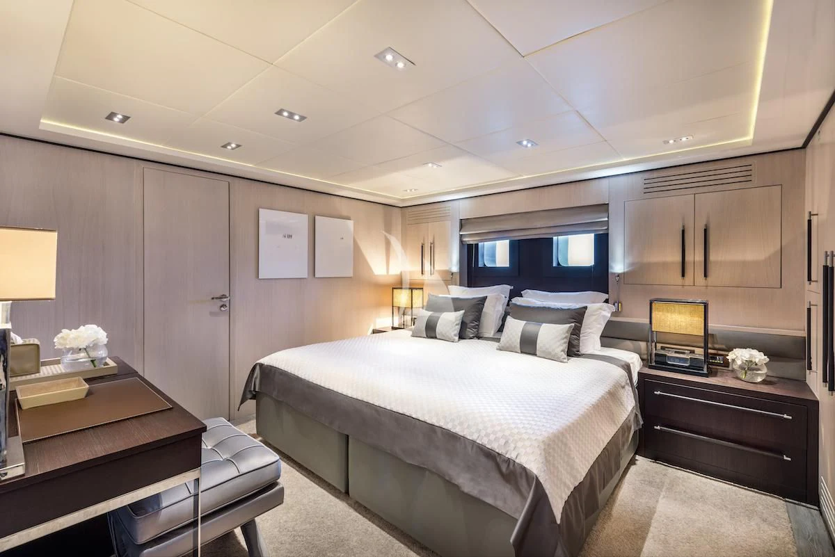 a bedroom with a bed and a desk aboard THANUJA Yacht for Sale