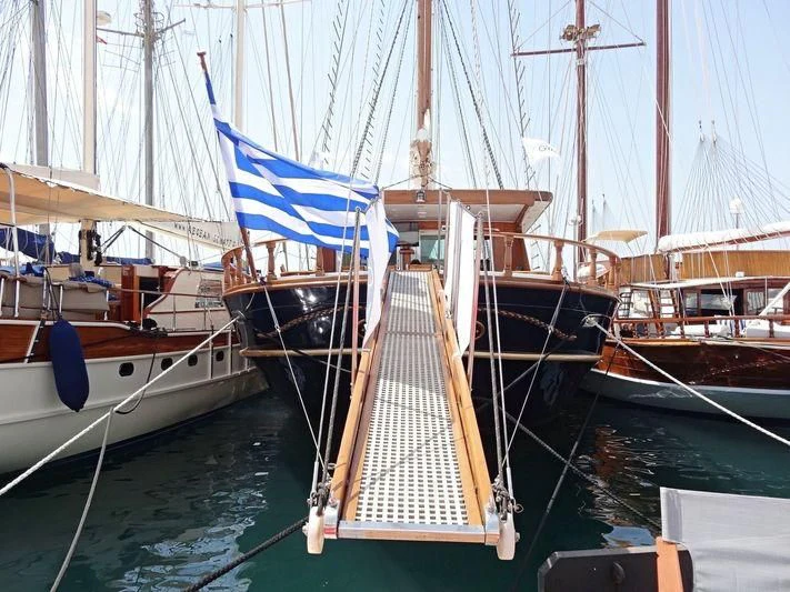 a boat with a flag on it aboard BLUE DREAM Yacht for Sale