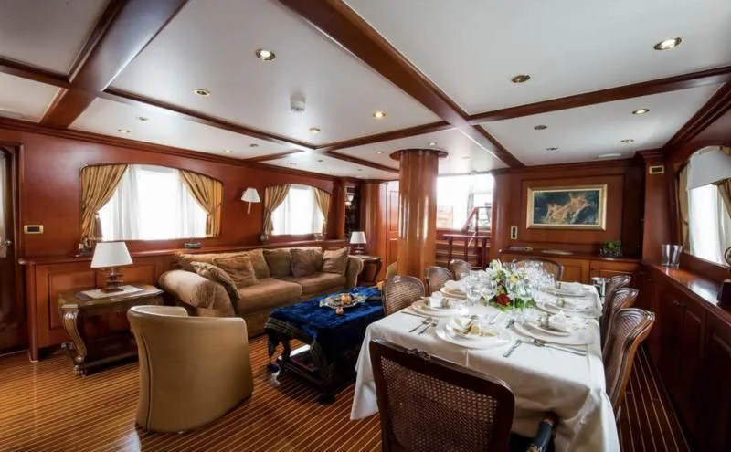 a large living room with a large bed and a dining table aboard BLUE DREAM Yacht for Sale