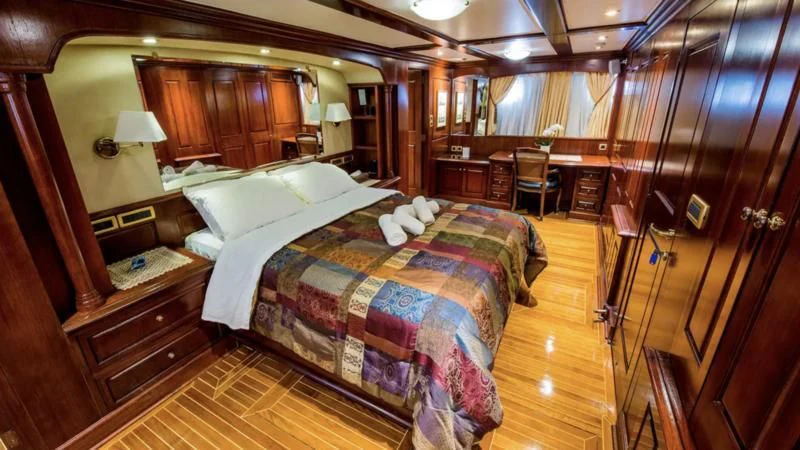 a bedroom with a bed and a desk aboard BLUE DREAM Yacht for Sale