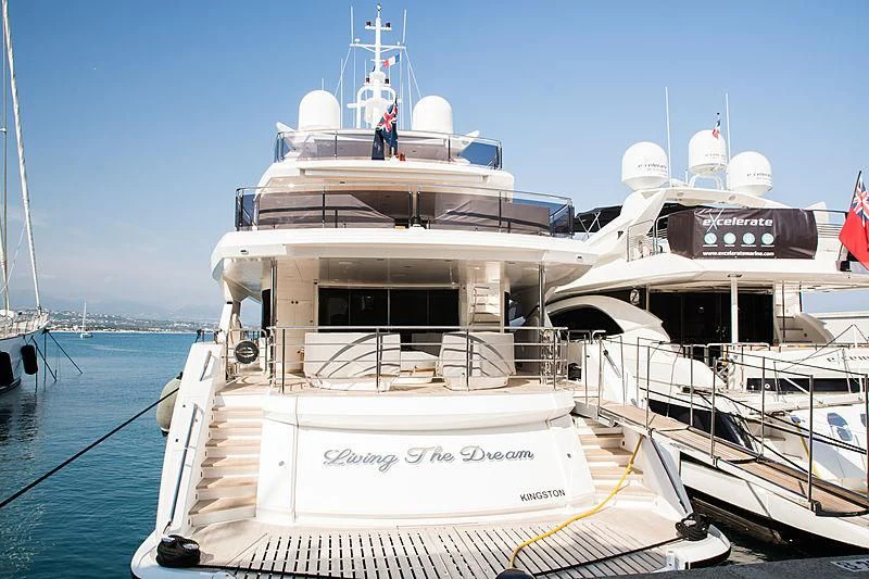 a large white boat with a flag on the front aboard LIVING THE DREAM Yacht for Sale