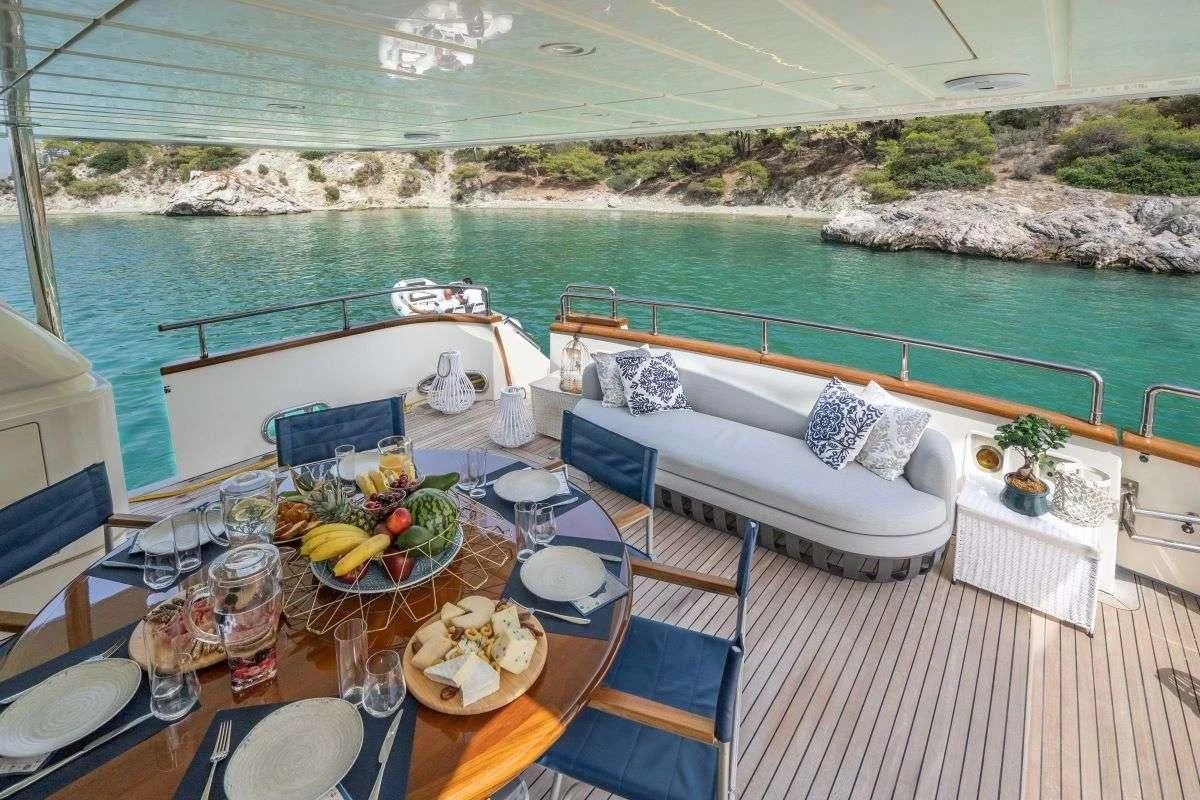 a table with plates and glasses on it next to a pool aboard ESTIA POSEIDON Yacht for Charter