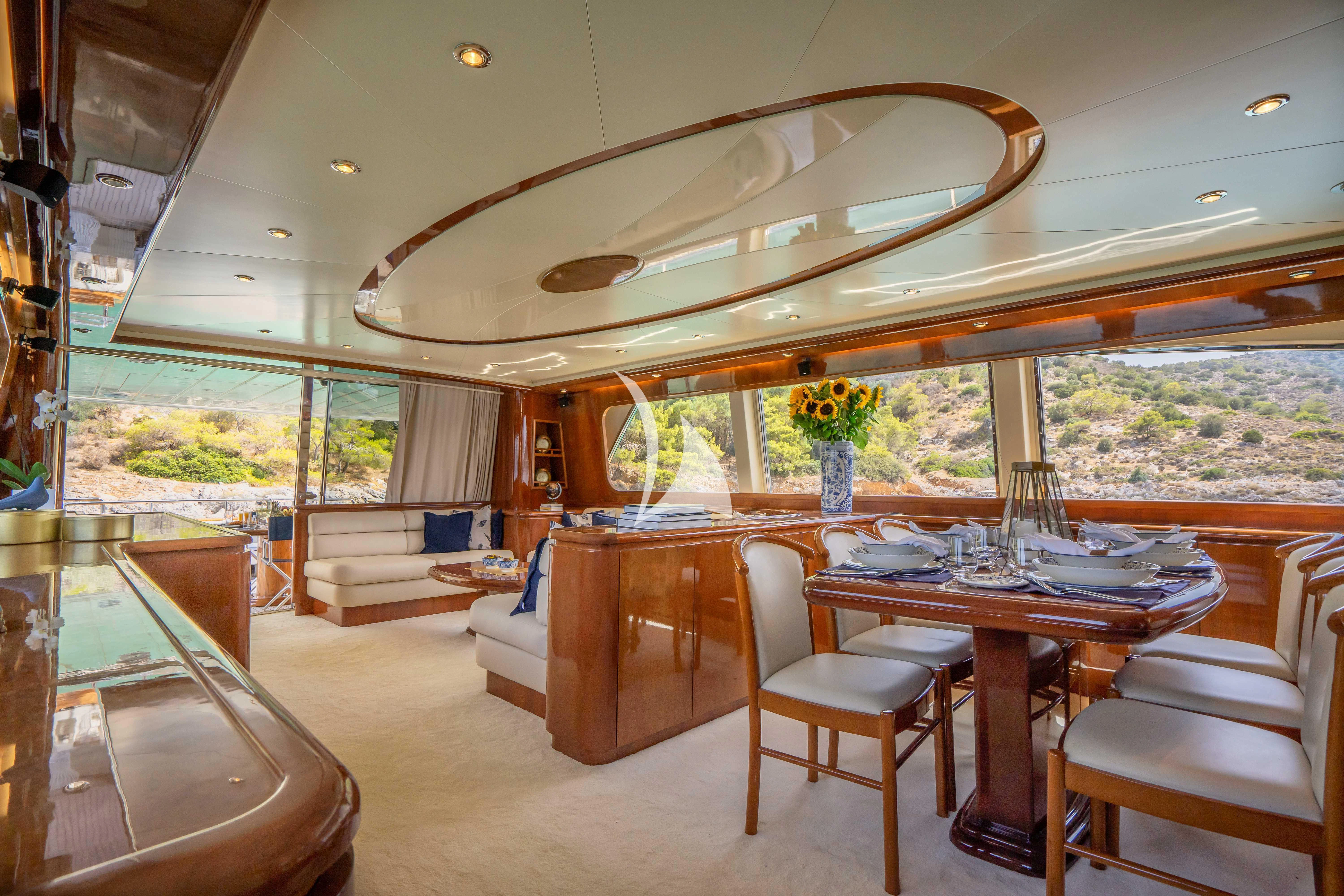 a large open space with a dining table and chairs aboard ESTIA POSEIDON Yacht for Charter