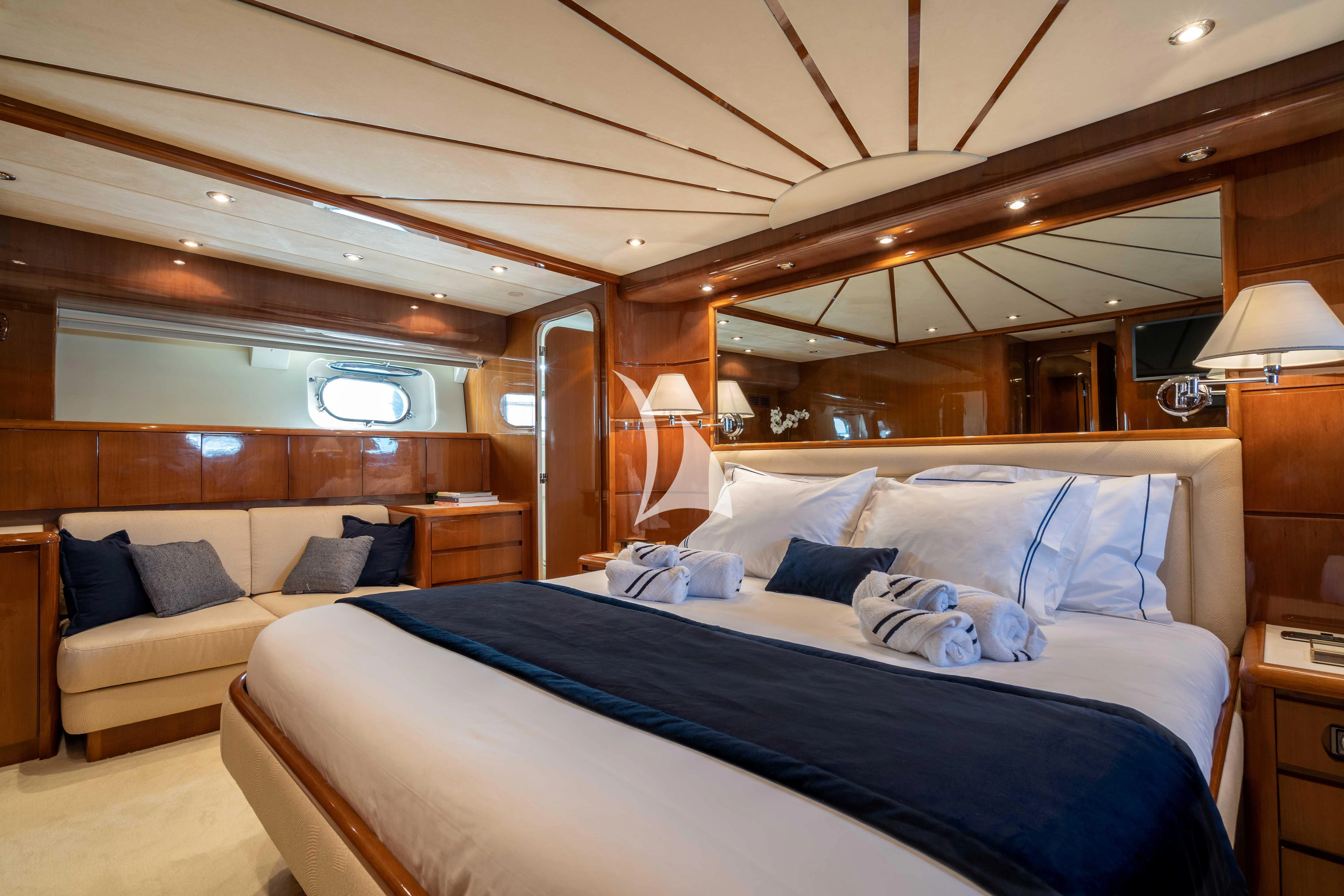 a bed with a blue comforter aboard ESTIA POSEIDON Yacht for Charter