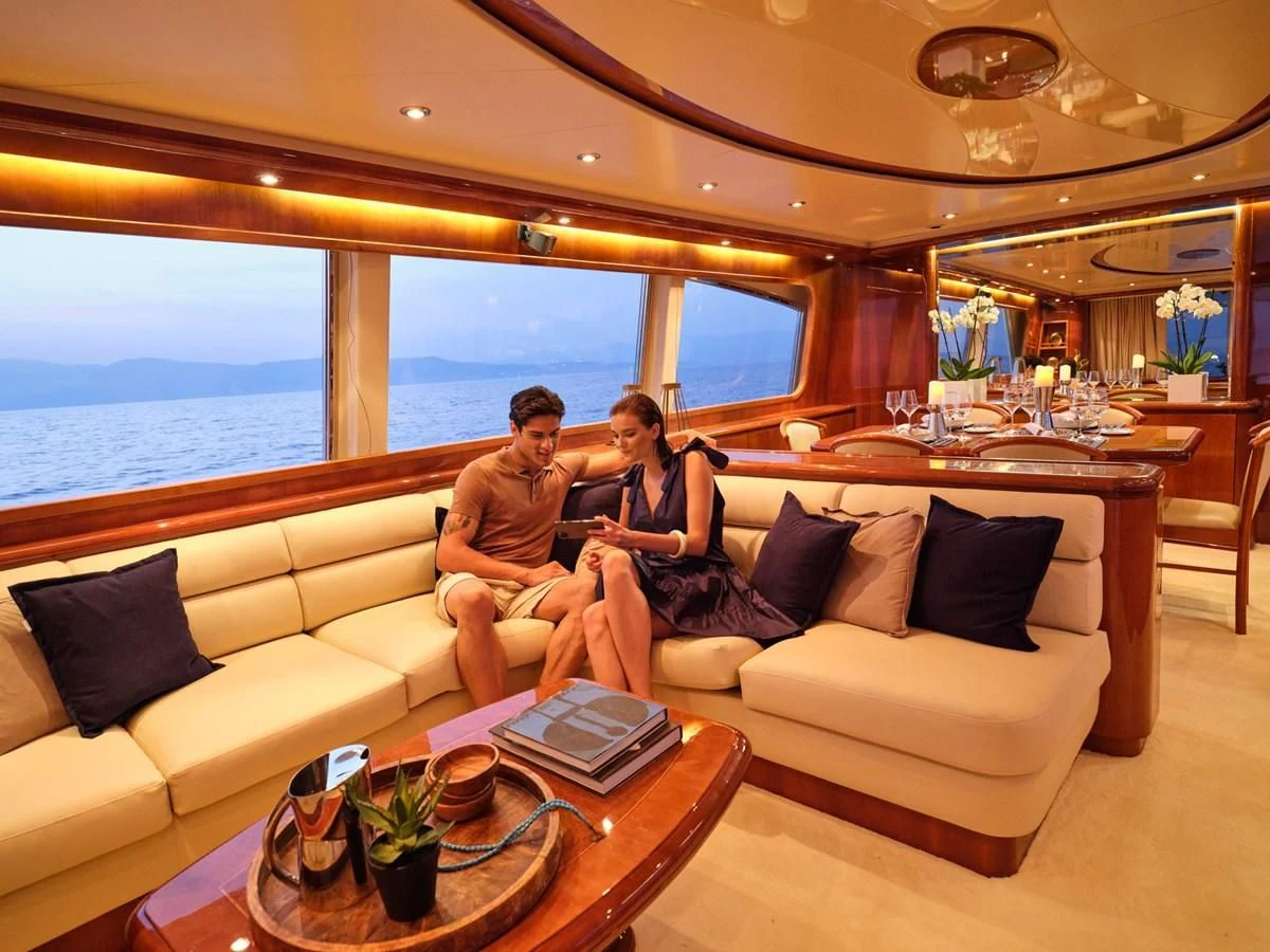 a couple sitting on a couch in a living room aboard ESTIA POSEIDON Yacht for Charter
