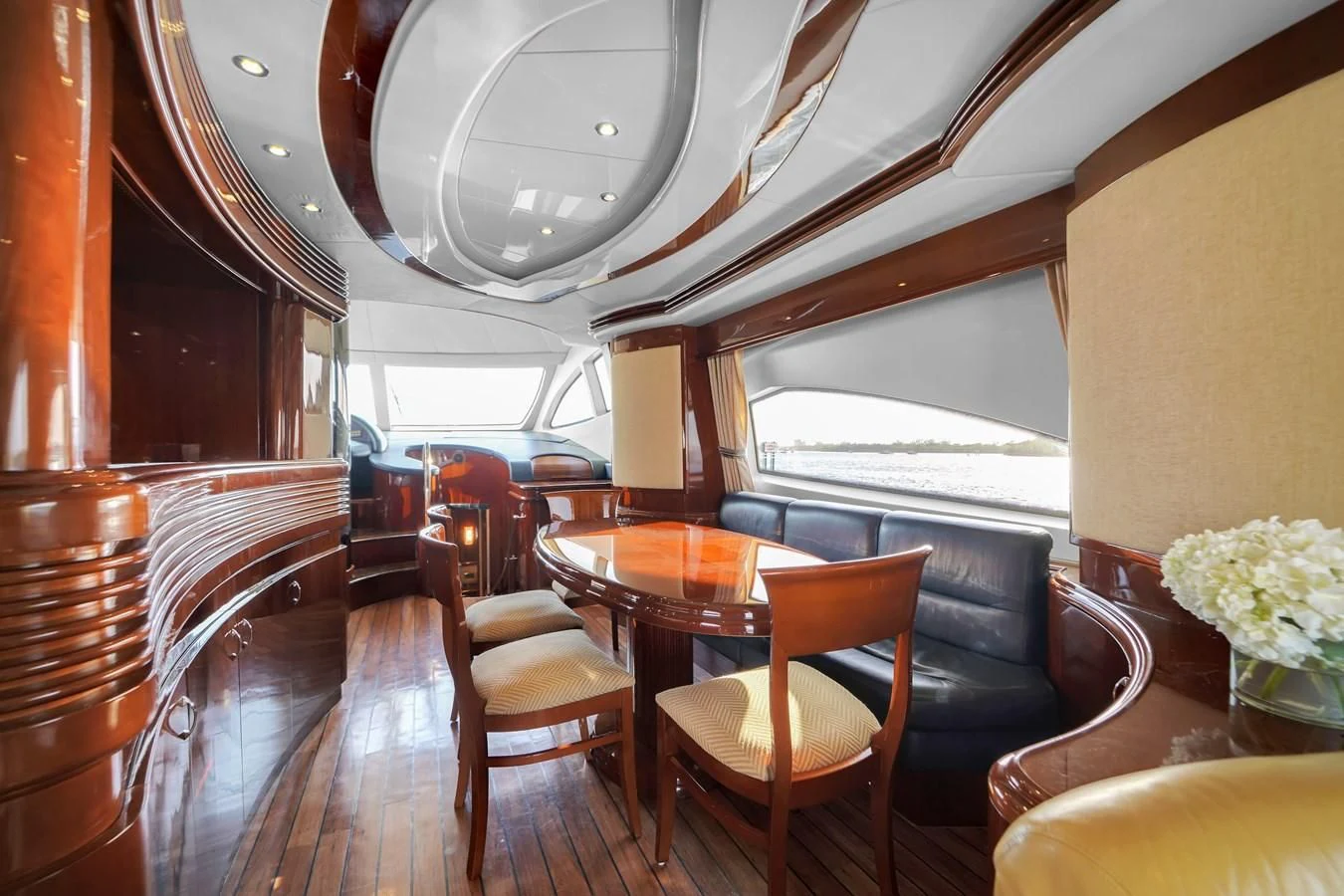 a room with a wood floor and chairs and a large window aboard AZIMUT 80 2003 Yacht for Sale