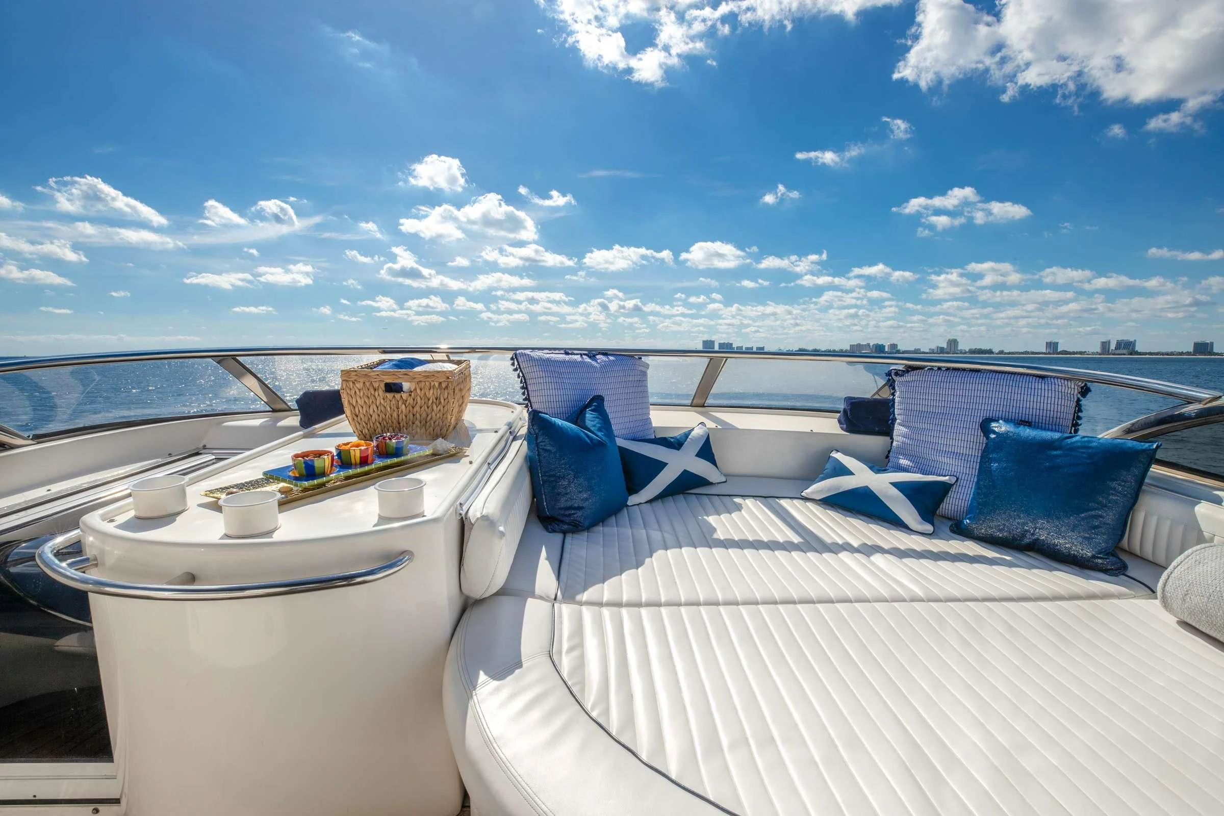 a bed with a white bed and blue pillows on it aboard LEOLENA Yacht for Sale